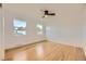 Bright bedroom with hardwood floors, two windows, neutral paint, and ceiling fan at 4244 W Monmouth Ave, Littleton, CO 80123
