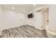 Bright bedroom featuring modern wood floors, a wall-mounted TV, and white walls with white doors at 4244 W Monmouth Ave, Littleton, CO 80123