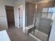 Bathroom featuring tiled shower, glass door and shower seat adjacent to walk-in closet and doorway at 4225 Ridgewalk Pt, Castle Rock, CO 80108