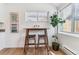 Breakfast nook with wood table, two stools, modern art, and natural light at 2550 Kendall St, Edgewater, CO 80214