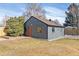 Charming home exterior with a well-maintained lawn, fresh paint, and inviting orange front door at 2550 Kendall St, Edgewater, CO 80214