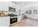 Bright kitchen with stainless steel appliances adjacent to the breakfast nook with table and stools at 2550 Kendall St, Edgewater, CO 80214