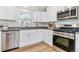 Bright kitchen featuring white cabinets, stainless steel appliances, and wood-look floors at 2550 Kendall St, Edgewater, CO 80214