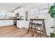 Open kitchen and breakfast nook featuring white cabinets, stainless steel appliances, and wood-look floors at 2550 Kendall St, Edgewater, CO 80214