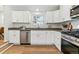 Bright kitchen featuring white cabinets, stainless steel appliances, gray counters, and wood-look floors at 2550 Kendall St, Edgewater, CO 80214