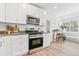 Bright kitchen with stainless steel appliances adjacent to the breakfast nook with table and stools at 2550 Kendall St, Edgewater, CO 80214