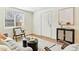 Bright living room featuring light wood floors, a modern rug, and a large window that brings in natural light at 2550 Kendall St, Edgewater, CO 80214