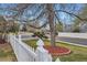 Front yard with a mature tree and a white picket fence enhancing the home's curb appeal at 5294 S Prescott St, Littleton, CO 80120