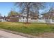 Well-manicured front yard of a home with a brick accent, a large tree, and a white picket fence at 5294 S Prescott St, Littleton, CO 80120