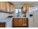 Traditional kitchen with wood cabinets, white appliances, and a bright window overlooking the yard at 5294 S Prescott St, Littleton, CO 80120