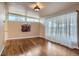 Bright living room with hardwood floors, large windows, and elegant sheer curtains at 5294 S Prescott St, Littleton, CO 80120