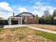 Wide backyard with a modern pergola, black fence, brick accents, and green grass details at 3458 N Clayton St, Denver, CO 80205