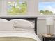 Bright bedroom with white linens, decorative pillows, and sunny windows offering a view of the outdoors at 3458 N Clayton St, Denver, CO 80205