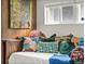 Charming bedroom featuring colorful throw pillows and a cozy design with artwork and a window at 3458 N Clayton St, Denver, CO 80205