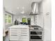 Contemporary kitchen with stainless steel appliances, quartz island, and an open view to the living area at 3458 N Clayton St, Denver, CO 80205