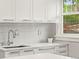 Bright kitchen featuring white cabinets, quartz countertops, tile backsplash, and stainless steel faucet at 3458 N Clayton St, Denver, CO 80205
