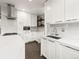 Modern white kitchen with stainless steel appliances, quartz countertops, and tiled backsplash at 3458 N Clayton St, Denver, CO 80205