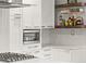 Bright kitchen featuring white cabinets, stainless steel appliances, and stylish open shelving with curated decor at 3458 N Clayton St, Denver, CO 80205