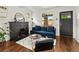 Comfortable living room with fireplace, hardwood floors, natural light, sofa, and access to the front door at 3458 N Clayton St, Denver, CO 80205