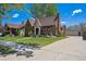 Charming brick home featuring a well-maintained lawn, a turret and a long driveway leading to a detached garage at 4434 Grove St, Denver, CO 80211