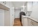 Bright laundry room features modern washer, sink, countertop and cabinet storage on hardwood floors at 4434 Grove St, Denver, CO 80211