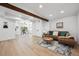 Spacious living room featuring wood floors, a wood beam, recessed lights, and stylish decor at 4434 Grove St, Denver, CO 80211