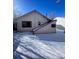 View of home's back and detached garage in winter at 926 Perry St, Denver, CO 80204