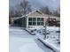 Ranch style home with a sunroom and snowy yard at 926 Perry St, Denver, CO 80204