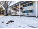 Condo building exterior showcasing a snow covered lawn and building facade at 4980 E Donald Ave # 14, Denver, CO 80222