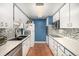 Galley style kitchen with blue walls, tile backsplash and stainless steel appliances at 4980 E Donald Ave # 14, Denver, CO 80222