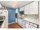 Clean kitchen featuring blue walls, tile backsplash and white cabinets at 4980 E Donald Ave # 14, Denver, CO 80222