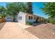 Charming light blue single-story home with a detached garage and a long driveway on a sunny day at 2205 S King St, Denver, CO 80219