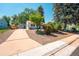 Inviting front yard featuring a well-manicured lawn, mature trees, and a detached garage with extended driveway at 2205 S King St, Denver, CO 80219