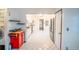 Spacious kitchen leading to living area with updated appliances, white cabinetry, and neutral tile flooring at 2205 S King St, Denver, CO 80219