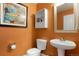 Charming powder room featuring orange walls, updated fixtures and stylish decor at 737 Novick Ct, Castle Rock, CO 80109
