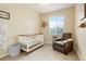 Cozy Bedroom featuring neutral walls, a crib, accent chair, and a large window at 737 Novick Ct, Castle Rock, CO 80109