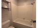 Clean, bright bathroom with white tile, a bathtub, and modern toilet at 539 Wright St # 203, Lakewood, CO 80228
