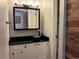 Stylish bathroom featuring a vessel sink, black countertop, and wood-paneled accent wall at 539 Wright St # 203, Lakewood, CO 80228