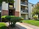 Close up view of a tan condo building showing the front entrance, stairwell, and nicely kept lawn at 539 Wright St # 203, Lakewood, CO 80228
