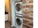 Stackable Washer and Dryer with modern features, situated next to a wood accent wall at 539 Wright St # 203, Lakewood, CO 80228