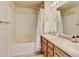 Bathroom features a double vanity, shower-tub combo with a shower curtain, and functional tile flooring at 7245 Prairie Cir, Longmont, CO 80504