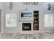 Modern fireplace with decorative tile surround, built-in shelving, and bright light from nearby windows at 7245 Prairie Cir, Longmont, CO 80504