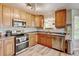 Modern kitchen with stainless steel appliances, wood cabinetry, and wood-look flooring at 7245 Prairie Cir, Longmont, CO 80504