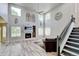 Spacious living room with a fireplace, tall ceilings, large windows, and staircase at 7245 Prairie Cir, Longmont, CO 80504