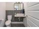 Compact bathroom with penny tile floor and accent wall featuring a modern floating sink at 5610 S Sycamore St, Littleton, CO 80120