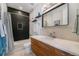 Sleek bathroom features a shower/tub combo, modern vanity with white countertop, and a decorative mirror at 5610 S Sycamore St, Littleton, CO 80120