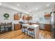 Modern kitchen featuring an island with seating, stainless steel appliances, and hardwood floors at 5610 S Sycamore St, Littleton, CO 80120