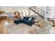 Open living area featuring a comfortable blue sectional, hardwood floors, and a modern staircase at 5610 S Sycamore St, Littleton, CO 80120