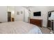 Bright main bedroom featuring neutral colors, a TV, and a stylish dresser with a large mirror at 5610 S Sycamore St, Littleton, CO 80120