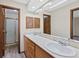 Bathroom featuring a double sink vanity, tile countertops, and a framed glass shower at 141 S Fraser Cir, Aurora, CO 80012